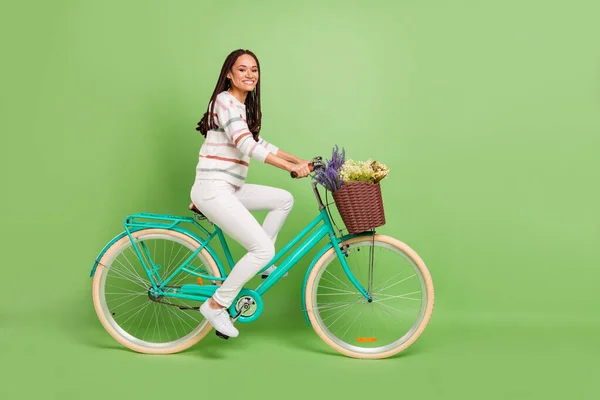 Foto lateral de perfil de tamaño completo de la joven negra feliz sonrisa positiva paseo bicicleta vehículo viaje aislado sobre fondo de color verde —  Fotos de Stock