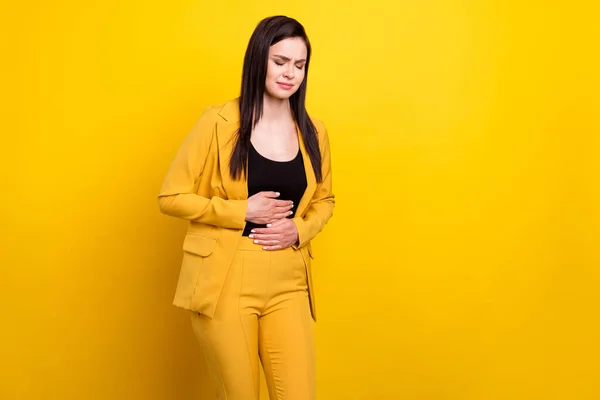 Фото молодой женщины чувствуют сильную боль в животе больной инфекцией спазм плохо изолированы на желтом фоне цвета — стоковое фото