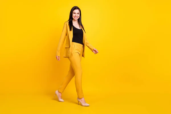 Tamaño completo perfil lado de la foto de la joven atractiva mujer feliz sonrisa positiva ir caminar paso aislado sobre fondo de color amarillo —  Fotos de Stock