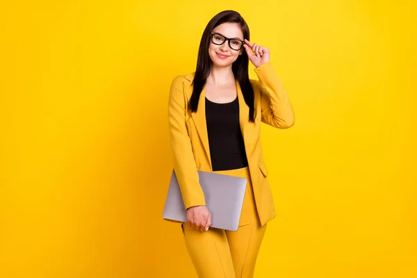 Фото молодой деловой женщины счастливой позитивной улыбкой руки касания очки держать ноутбук изолированы на желтом фоне цвета — стоковое фото