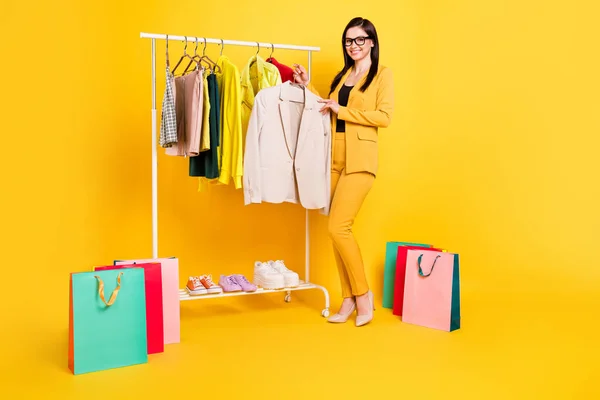 Pełne zdjęcie ciała młodej kobiety szczęśliwy uśmiech wybrać nowe ubrania sklep torby klientów zakupy izolowane na żółtym tle koloru — Zdjęcie stockowe