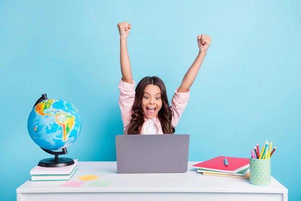 Foto van jong blij enthousiast positief goed humeur gelukkig meisje verhogen vuisten in de overwinning doen huiswerk geïsoleerd op blauwe kleur achtergrond — Stockfoto