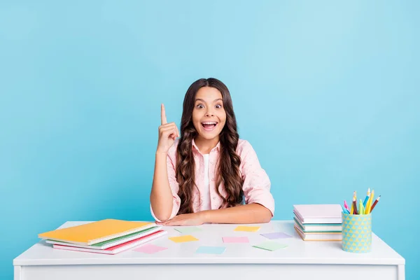 Porträtt av vackra förvånad unge sitter klassrum skrivbord bok copybook isolerad på blå färg bakgrund — Stockfoto