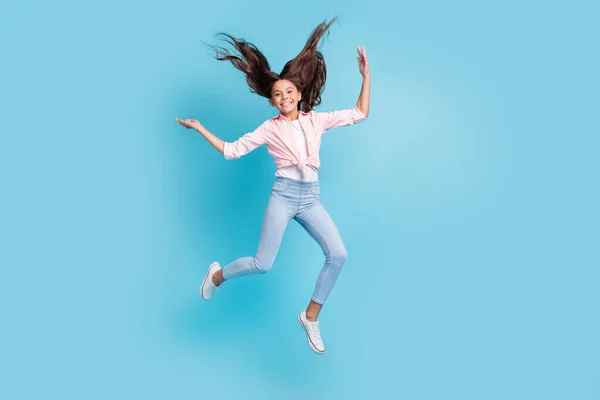 Foto em tamanho completo de pessoa da escola alegre enérgica saltando cabelo voando bom humor isolado no fundo de cor azul — Fotografia de Stock