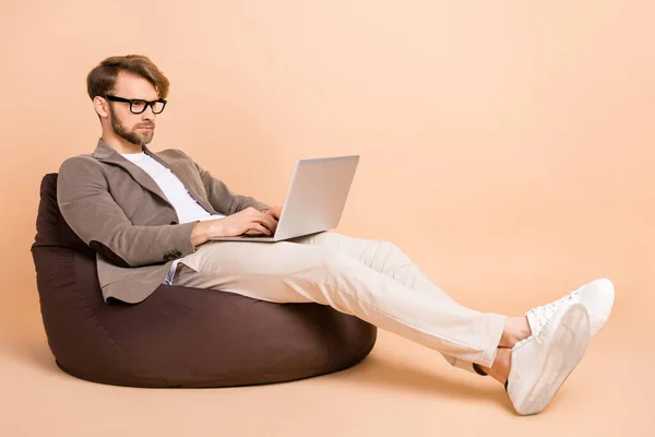 Foto de tamaño completo de hombre de negocios confiado enfocado serio que trabaja en el ordenador portátil aislado en el fondo de color pastel —  Fotos de Stock