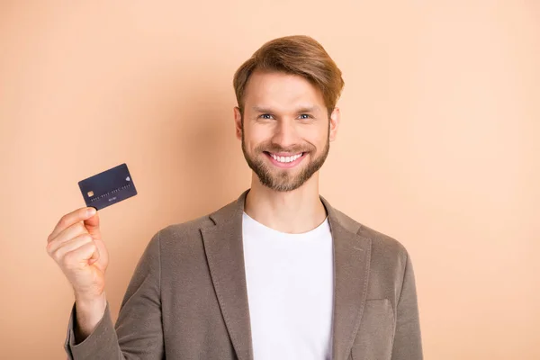 Foto van optimistisch mooi blond haar man toon kaart dragen grijs jasje geïsoleerd op beige achtergrond — Stockfoto