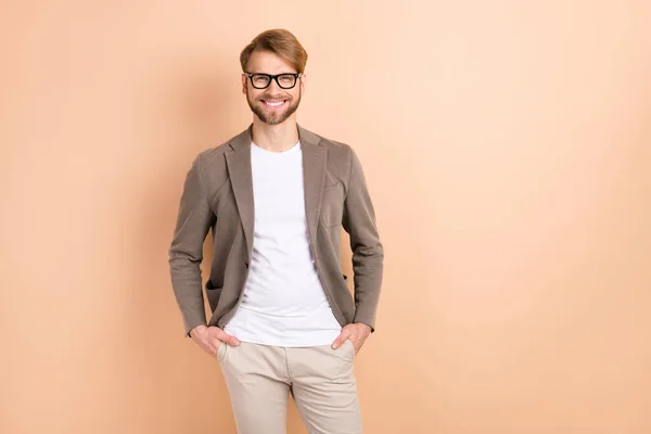 Foto de optimista pelo rubio agradable hombre usar gafas chaqueta gris aislado sobre fondo de color beige — Foto de Stock