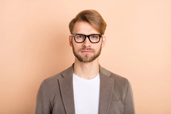 Fénykép komoly magabiztos fiatal srác visel kabát szemüveget elszigetelt bézs színű háttér — Stock Fotó