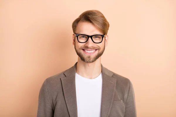 Фото уверенного в себе молодого джентльмена, одетого в блейзерные очки, улыбающегося на бежевом фоне — стоковое фото