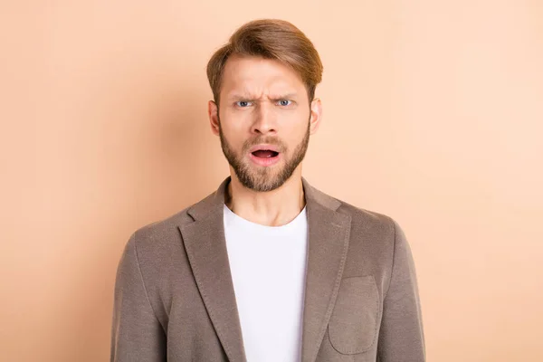 Foto von beeindruckt verärgert junger Herr gekleidet Blazer große Augen offenen Mund isoliert beige Farbe Hintergrund — Stockfoto