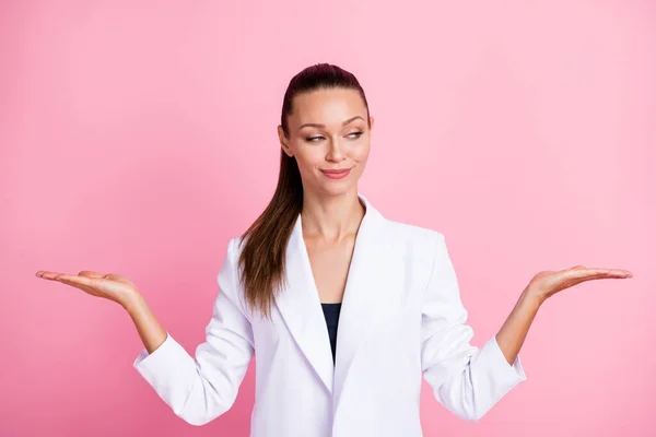 Foto de dulce linda mujer joven vestida de blanco chaqueta mirando sosteniendo brazos espacio vacío aislado pastel color rosa fondo —  Fotos de Stock