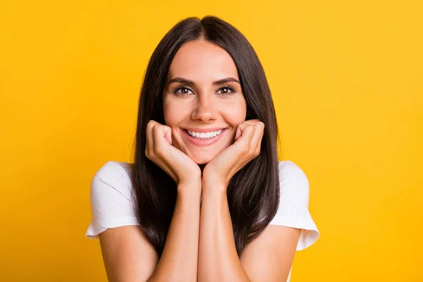 Foto de jovem atraente mulher de cabelo castanho feliz sorriso positivo mãos sonho tocar bochechas isoladas sobre fundo de cor amarela — Fotografia de Stock