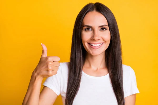 Fénykép a fiatal vonzó nő boldog pozitív mosoly mutatják hüvelykujj-up, mint hűvös tökéletes hirdetés elszigetelt sárga színű háttér — Stock Fotó