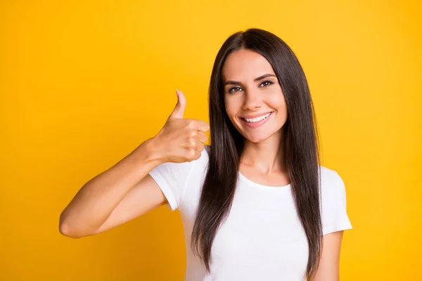 Foto de una joven bonita y brillante vestida con una camiseta blanca que muestra el pulgar hacia arriba aislado color amarillo de fondo — Foto de Stock