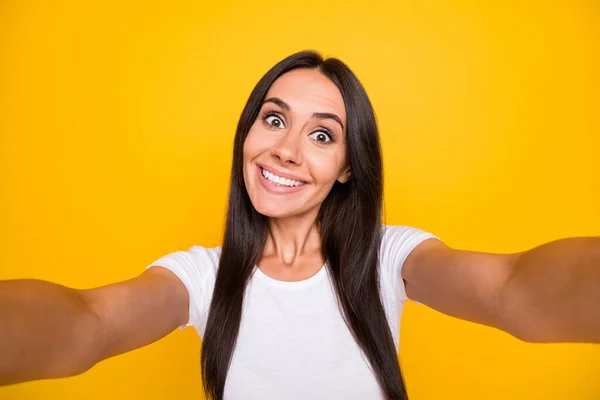 Photo of shiny funny young woman dressed white t-shirt tacking selfie smiling isolated yellow color background — Stock Photo, Image