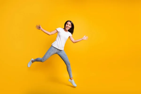 Full size foto van schattige mooie jonge vrouw springen verhogen handen goed humeur geïsoleerd op gele kleur achtergrond — Stockfoto