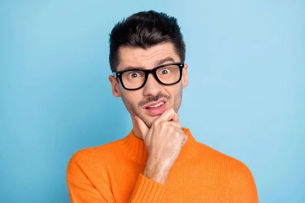 Foto de un brazo de hombre joven en la barbilla gafas de desgaste rostro hosco desgaste suéter aislado sobre fondo de color azul — Foto de Stock