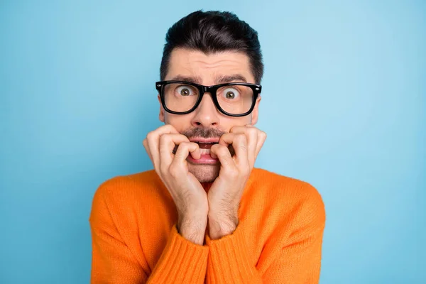 Retrato de cara bonito nervoso mordendo unha dedo olhando óculos isolados no fundo de cor azul — Fotografia de Stock