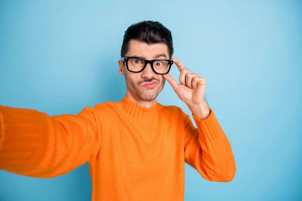 Foto de cara jovem fazer selfie mão tocar óculos lábios inchados hesitar isolado no fundo de cor azul — Fotografia de Stock