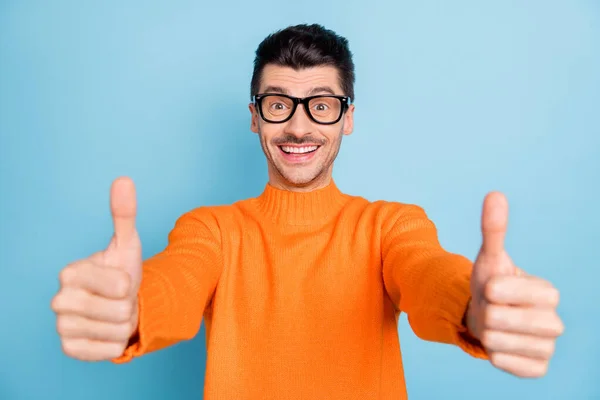 Porträtt av glada stilig kille visar två armar tummen upp strålande leende isolerad på blå färg bakgrund — Stockfoto