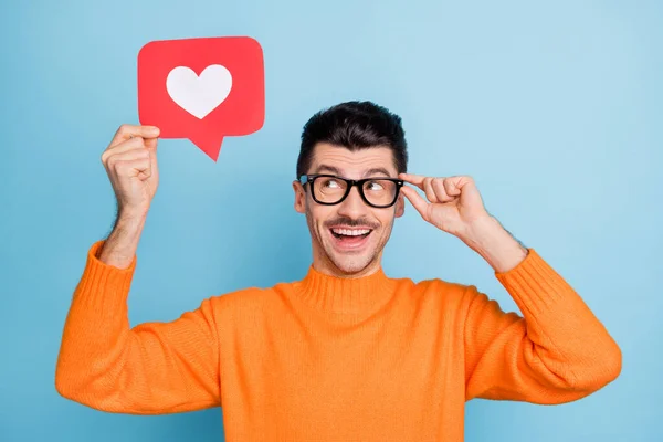 Retrato de impressionado homem positivo olhar como papel cartão mão toque óculos bom humor isolado no fundo de cor azul — Fotografia de Stock