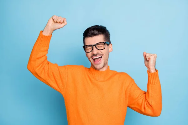 Foto de jovem animado homem feliz sorriso positivo alegrar vitória vitória sorte sucesso punhos mãos isoladas sobre fundo de cor azul — Fotografia de Stock