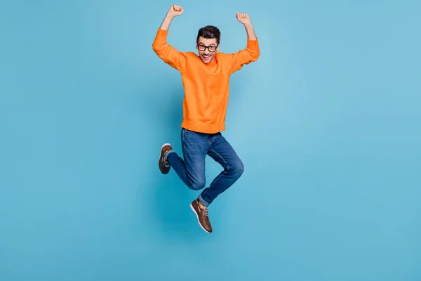 Foto de corpo inteiro de jovem animado homem feliz sorriso positivo saltar para cima alegrar vitória isolada sobre fundo de cor azul — Fotografia de Stock