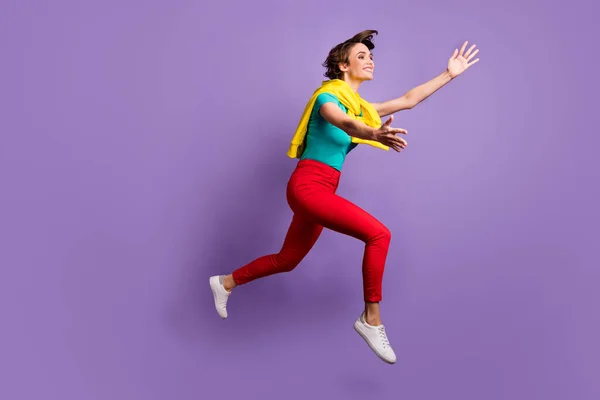 Pleine longueur photo de dame sauter bras vide espace porter noué pull t-shirt pantalon chaussures isolé violet couleur fond — Photo