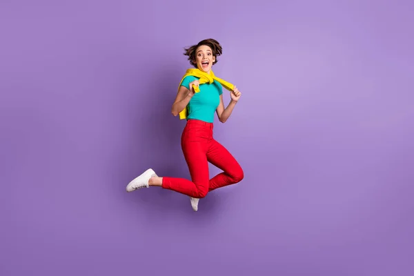 Teljes hosszúságú fotó hölgy ugrás nyitott száj kopás kötött pulóver póló nadrág cipő izolált lila színű háttér — Stock Fotó