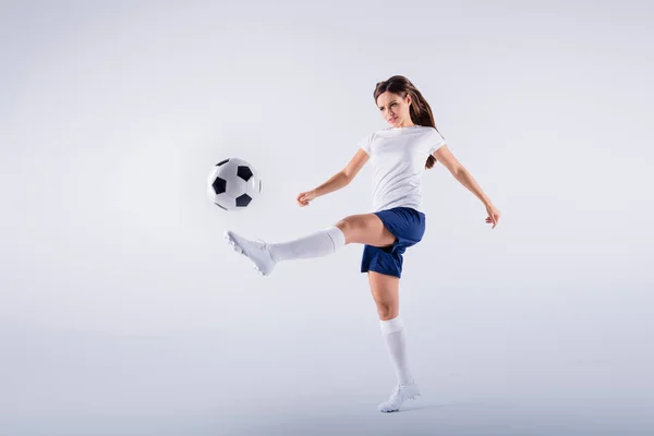 Longitud completa tamaño del cuerpo vista de bonito atractivo delgado deportivo enfocado recta chica saltando jugando patadas golpeando bola aislado en blanco claro gris pastel color fondo — Foto de Stock