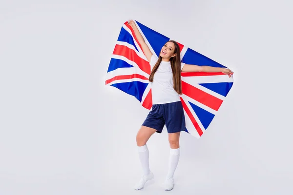 Foto de tamaño completo de alegre alegre alegre diversión chica fan del fútbol mantenga bandera del Reino Unido apoyo a la selección nacional en uefa campeonato mundial de la Copa desgaste uniforme aislado sobre fondo de color gris —  Fotos de Stock