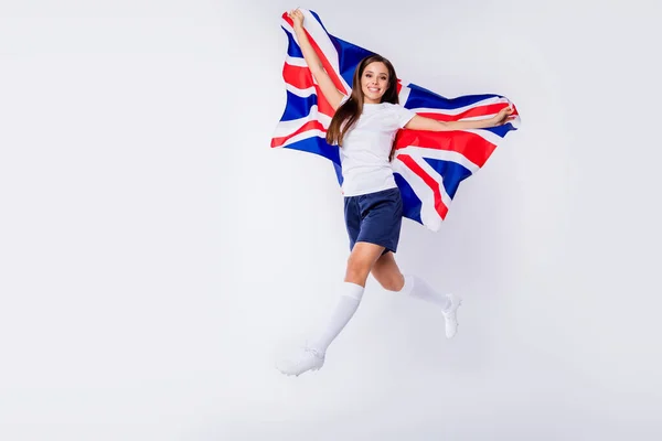 Foto de tamaño completo de fan de fútbol chica positiva disfrutar de su gol favorito puntuación del equipo en la final mundial de fútbol Copa salto mantenga bandera británica usar calcetines aislados sobre fondo de color gris —  Fotos de Stock