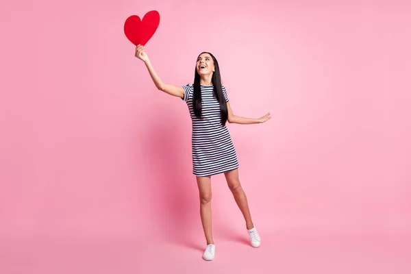 Plná délka tělo velikost pohled na krásné veselý fit dívka drží v ruce srdce létání baví izolované přes růžové pastelové barvy pozadí — Stock fotografie