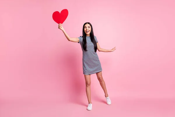 Comprimento total do corpo tamanho vista de menina muito alegre esbelta segurando na mão coração voando apreciando isolado sobre cor pastel rosa fundo — Fotografia de Stock