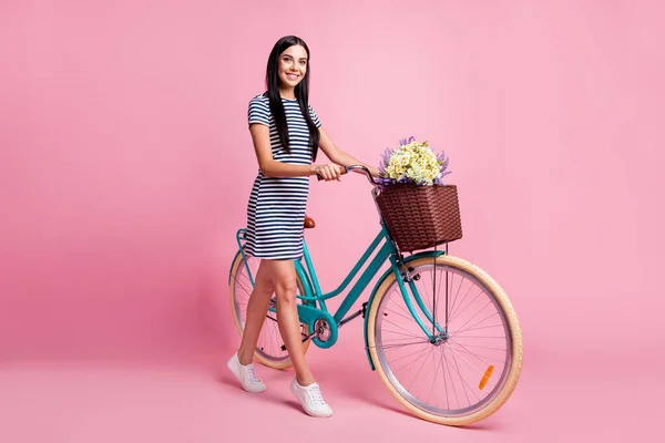 전체 몸길이의 프로필 옆에 있는 아름다운 쾌활 한 소녀가 자전거를 타고 가는 모습 분홍색 파스텔 색 배경에 고립된 채 시간을 보내는 모습 — 스톡 사진