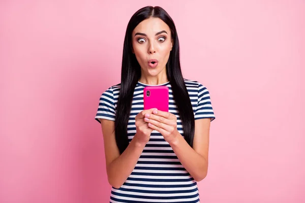 Retrato de cerca de la encantadora chica asombrada enfocada usando gadget labios enfurecidos navegando multimedia aislado sobre fondo de color pastel rosa —  Fotos de Stock