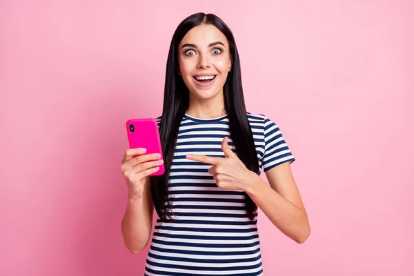 Fénykép portré csodálkozó nő ujjal mutató telefon egyik kezében elszigetelt pasztell rózsaszín színű háttér — Stock Fotó
