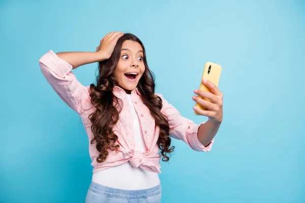 Foto de la joven feliz sorprendida sorprendida sorprendida chica sonriente sostener la mano uso de la cabeza teléfono aislado en el fondo de color azul — Foto de Stock