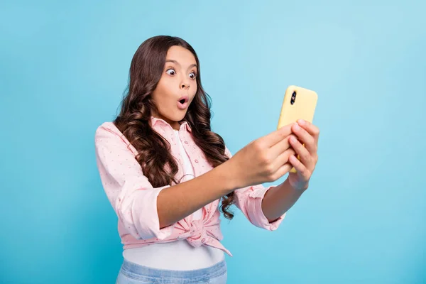 Foto de joven hermosa sorprendida sorprendida chica sorprendida usando teléfono inteligente ve aversión aislada en el fondo de color azul — Foto de Stock