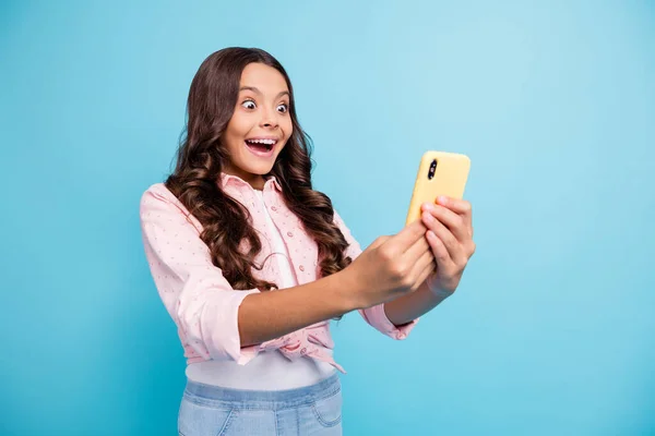 Foto de la joven feliz emocionado chica sonriente positiva loca mantenga mirada teléfono inteligente aislado sobre fondo de color azul — Foto de Stock