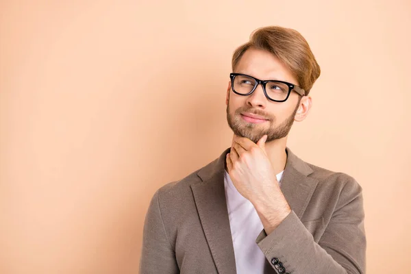 Foto de otimista agradável loiro cabelo homem olhar vazio espaço desgaste óculos cinza jaqueta isolada no fundo cor bege — Fotografia de Stock