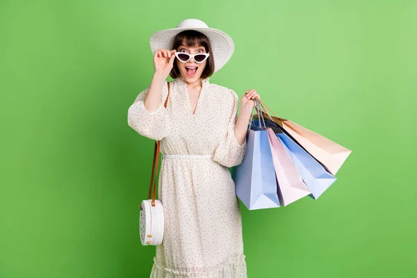 Photo portrait of girl amazed in sunglass keeping bags in shopping center isolated on pastel green color background — Stock Photo, Image