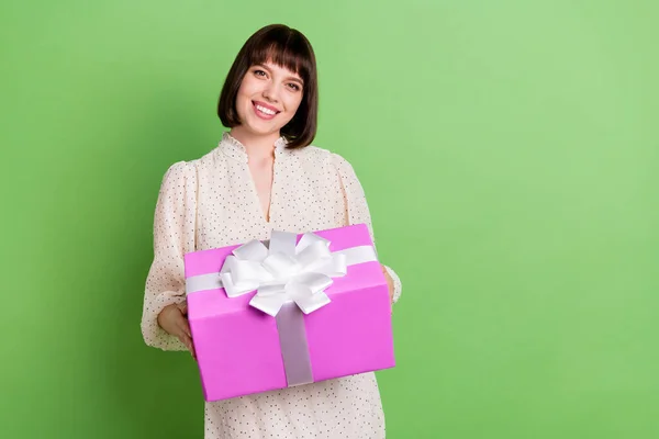 Фото молодой привлекательной девушки счастливой позитивной улыбкой провести настоящее торжество коробке изолированы на зеленом фоне цвета — стоковое фото