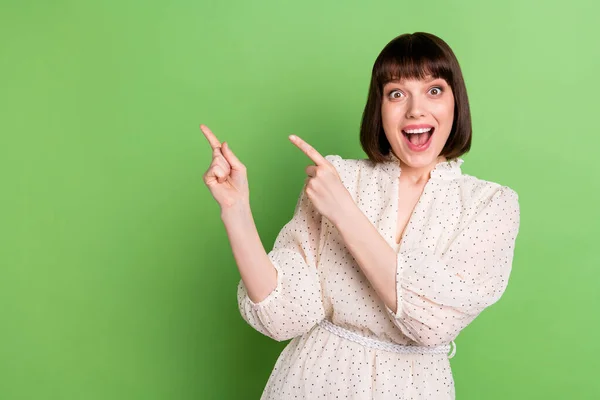 Φωτογραφία του νεαρού ενθουσιασμένοι κορίτσι ευτυχής θετικό χαμόγελο σημείο δάχτυλα κενό χώρο διαφημίσεις promo προτείνουν απομονωμένο πάνω από πράσινο χρώμα φόντο — Φωτογραφία Αρχείου