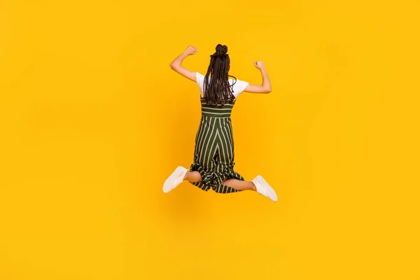 Lunghezza totale dimensioni del corpo posteriore dietro la vista di attraente ragazza fortunata saltando gioire isolato su sfondo di colore giallo brillante — Foto Stock