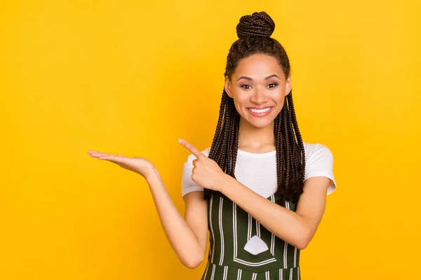 Foto av ung afro flicka glad leende peka finger produkt promo erbjuda annons val försäljning isolerad över gul färg bakgrund — Stockfoto