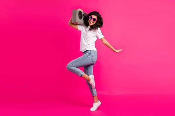 Foto de perfil em tamanho completo de senhora funky hold boom box desgaste óculos t-shirt jeans sapatilhas isoladas no fundo rosa — Fotografia de Stock