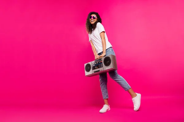 Fotografie celého těla krásné tisícileté dáma držet boom box nosit brýle tričko džíny tenisky izolované na růžovém pozadí — Stock fotografie