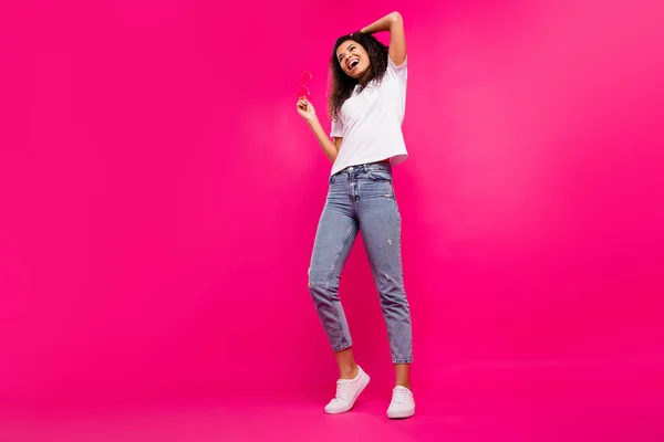 Full längd foto av cool tusenårig dam ser tomt utrymme slitage glasögon t-shirt jeans sneakers isolerade på rosa bakgrund — Stockfoto