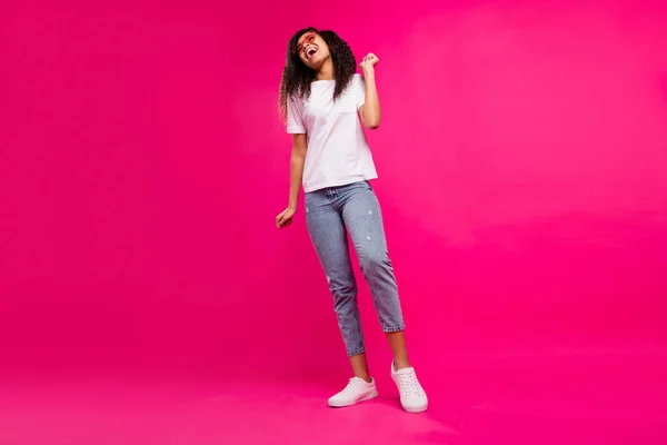 Corpo inteiro foto de impressionado jovem senhora dança desgaste óculos t-shirt jeans tênis isolado no fundo rosa — Fotografia de Stock